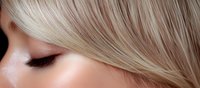 Close up view of platinum blonde hair and eye makeup on light skin tone woman showing smooth texture and professional styling for beauty and cosmetics industry.