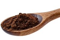 Ground dark cocoa powder in wooden spoon isolated on white background. Natural organic baking ingredient and food photography.