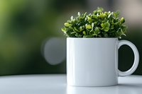 Small green artificial plant in white ceramic mug on light surface against blurred background with bokeh effect. Modern minimalist home decor styling.