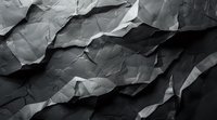 Dramatic black and white crumpled paper texture with deep shadows and angular folds creating abstract mountainous landscape effect. Artistic background for design projects.