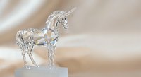 Crystal clear glass unicorn figurine standing on white base with elegant horn and mane details against soft blurred background for home decor and collectibles.