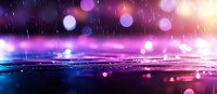 Dreamy purple and pink bokeh lights reflecting on wet surface during rain with blurred background creates magical atmospheric scene for romantic designs.