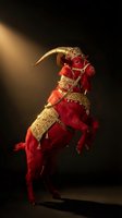 Red demon creature with golden horns and ornate armor in dramatic spotlight against dark background for fantasy and horror themed projects.