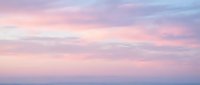 Soft pastel sky with pink and purple clouds at sunset or sunrise creating dreamy atmospheric background for romantic and peaceful designs.