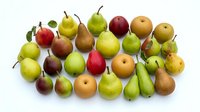 Assorted fresh pears and apples arranged on white background, including red, green, and golden varieties with stems. Suitable for food, nutrition, grocery, and healthy eating concepts.
