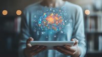 Digital brain hologram floating over tablet device held by professional in office setting, surrounded by business icons and data visualization elements. Artificial intelligence concept.