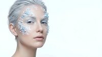 Young woman with silver glitter face art and platinum hair on white background for beauty and fashion concepts.