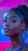Young African American woman with braided hair in vibrant neon lighting with purple and blue tones for fashion and beauty concepts.