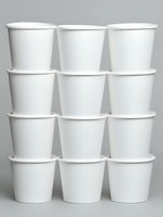 Stack of twelve white disposable paper cups arranged in rows on neutral background for food service and beverage industry applications.