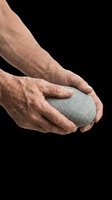 Mature male hands holding smooth gray stone on transparent background, ready for wellness, spa, meditation, and mindfulness design projects.