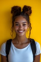 Young mixed race woman with curly hair buns wearing white t-shirt and backpack smiling against yellow background, natural beauty portrait for lifestyle content.