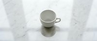 Empty ceramic cup on marble surface, isolated on white background, ready for product mockup, branding, and design projects.