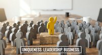 Yellow figure stands out among gray crowd on wooden blocks in office setting, representing leadership, uniqueness and standing apart in business environment.