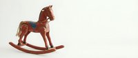 Vintage wooden rocking horse toy with saddle and bridle on neutral background. Classic childhood plaything for nursery decor and nostalgic themes.