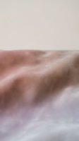 Soft fabric texture with flowing folds in dusty rose and cream tones, showcasing natural draping and material detail for design and textile projects.