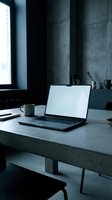 Modern laptop with blank white screen on concrete desk in minimalist office workspace with natural window light for mockup presentations.
