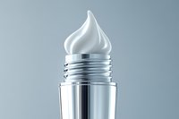 White cream swirl emerging from silver metallic container against gray background, minimalist cosmetic product photography for beauty and skincare advertising.