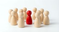 Red wooden pawn figure standing out among natural wood pawns on white background, representing leadership, uniqueness and standing out from crowd.