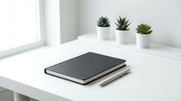 Minimalist workspace with black notebook and pen on white desk near window with small potted succulents for productivity and organization.