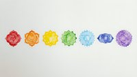 Colorful chakra crystals arranged in rainbow spectrum order on white background, isolated geometric gemstones for wellness, meditation and spiritual design projects.
