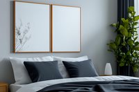 Modern bedroom interior with empty wooden frame mockup above bed, dark pillows, gray bedding and green plant near window in minimalist design.
