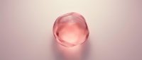 Translucent pink glass sphere with luminous glow on soft pastel background, suitable for luxury branding, cosmetics, wellness, and abstract design projects.