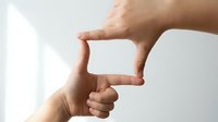 Hands forming frame gesture against white background for creative composition and visual planning concepts.