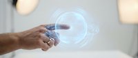 Hand pointing at glowing blue holographic circle with digital interface elements for futuristic technology and augmented reality applications.