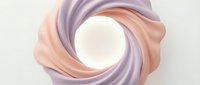 Silky fabric swirls in soft peach and lavender tones around a glowing white circular center, creating an elegant abstract composition suitable for backgrounds and design projects.