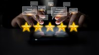 Businessman hands touching glowing five golden stars with customer feedback bubbles on dark background for rating and review concepts.