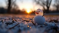 Tiny snowman with carrot nose and twig arms at sunset, glowing winter scene with snow crystals and bokeh light effects in foreground, magical holiday atmosphere.
