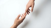 Two hands reaching toward each other in helping gesture on white background. Concept of support, assistance, teamwork and human connection.