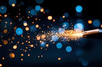 Magical sparks and bokeh lights burst from copper wire with blue and orange glowing particles against dark background creating dreamy atmosphere.