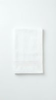 Folded white cotton terry towel isolated on white background, showcasing soft texture and ribbed border detail for spa, hotel, and bathroom concepts.