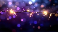 Glowing string lights with warm golden bulbs creating magical bokeh effect against purple blue background for holiday decorations and festive celebrations.