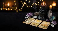 Mystical tarot card reading setup with crystals, candles and warm bokeh lights creating atmospheric fortune telling scene for spiritual guidance and divination practices.