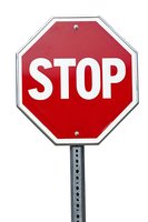 Red and white octagonal stop sign mounted on metal pole against white background, isolated with clean edges for easy digital integration into design projects.