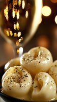 Seasoned potato gnocchi with herbs and spices served on dark plate with golden bokeh lights and wine glass reflections creating festive dining atmosphere.