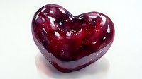 Glossy dark red glass heart on white background, romantic symbol with reflective surface and translucent deep crimson color creates elegant Valentine decoration.