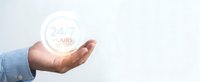 Professional businessman hand holding glowing 24 hours service symbol representing continuous customer support and round-the-clock business operations.
