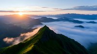 Majestic mountain peak rising above misty clouds at sunrise, dramatic aerial view of foggy valley with sunlight breaking through, green slopes in summer landscape.