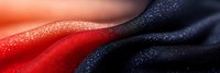 Macro abstract background with smooth gradient transition from bright coral red to deep navy blue colors featuring water droplets and textured surface.