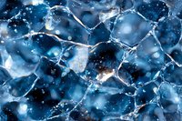 Macro photography of frozen ice crystals forming intricate geometric patterns in deep blue tones with light reflections and bokeh effects creating abstract winter texture.