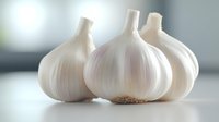 Fresh white garlic bulbs with papery skin arranged on clean surface for cooking and culinary preparation in modern kitchen setting.