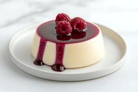 Creamy panna cotta dessert topped with fresh raspberries and raspberry sauce on white ceramic plate against light background. Elegant food styling.