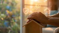 Hands protecting wooden house model with security and growth icons glowing above, symbolizing home insurance, property protection, and real estate investment planning.