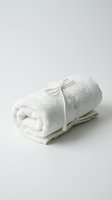 Rolled white terry towel tied with a rope bow on a light background, spa and wellness concept for bath, hotel, and self-care designs.