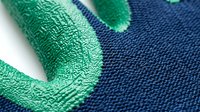 Closeup of woven fabric texture with green and navy blue colors, showing detailed thread weave pattern and material surface for textile design projects.