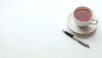 Minimalist workspace with white tea cup and elegant pen on clean surface for business and productivity concepts.