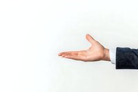 Male hand with open palm gesture against white background, showing business presentation or offering concept in professional setting.